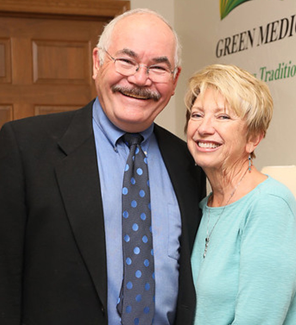 Dr. Kevin Green, MD and Karen Green, founders of Green Medicine of Wisconsin, in front of the clinic sign in Oshkosh